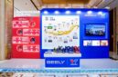 A display booth featuring Valvoline GEELY collaboration, showcasing co-developed lubricants and a timeline of their partnership, with product bottles arranged on a central table.