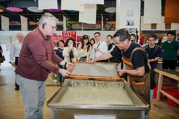 H.E. Mr. Karlis Eihenbaums,ambassador of Latvia to China, tries his hand at the traditional craft of Xuan papermaking.